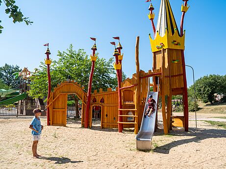 Wooden castle playground with slide at CLICOCHIC campsite in Padirac.