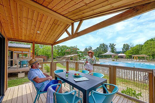 Mobile home terrace overlooking pool and slides at CLICOCHIC Les Secrets de Padirac campsite in Padirac (46).