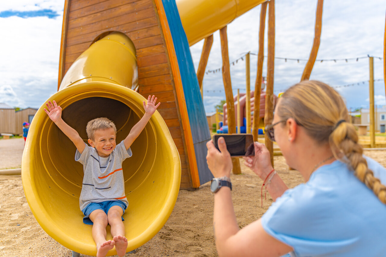 Slide, smiling child at VAGUES OCEANES Licorne campsite in Dunkerque (59).