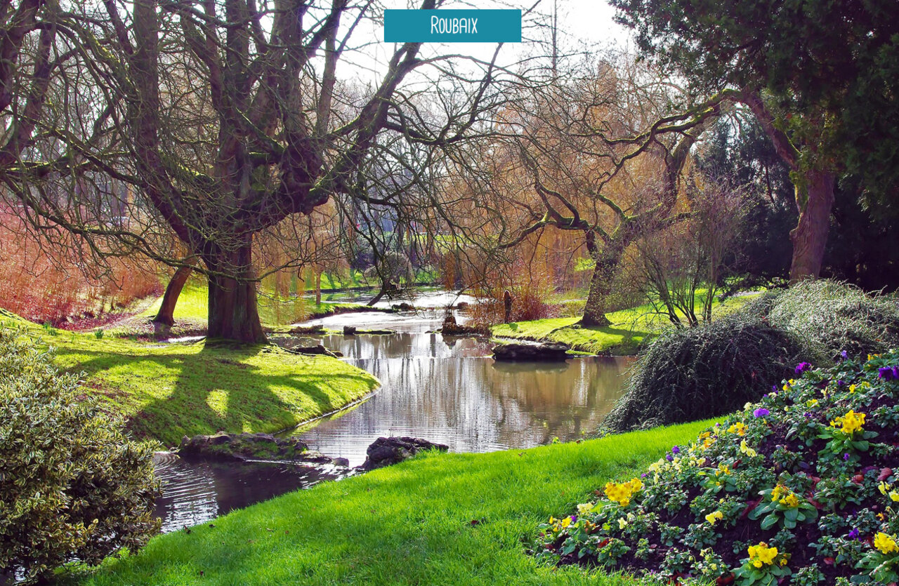 Landscaped park with winding river and colorful flowers in Roubaix, Hauts-de-France.