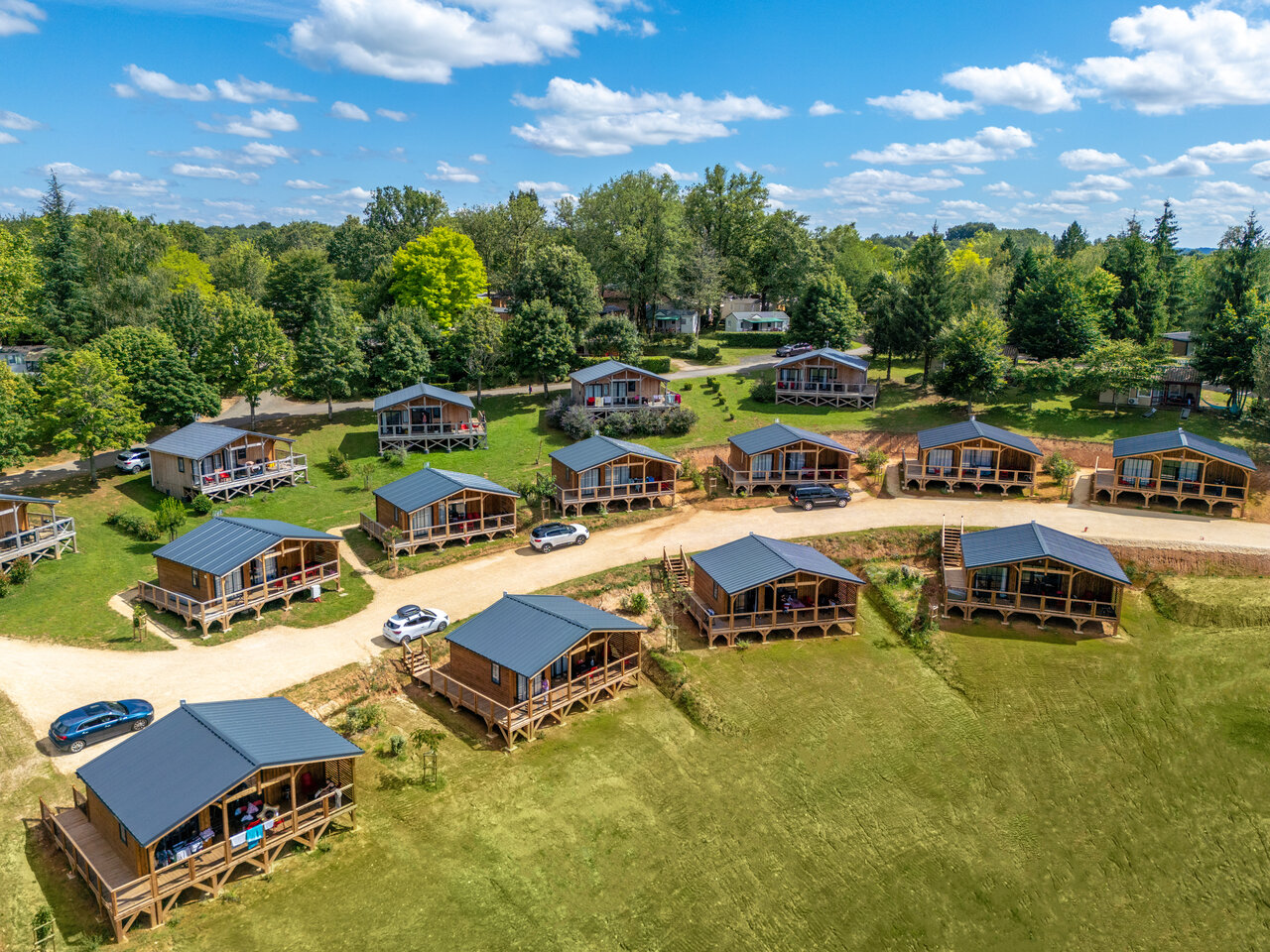 Wooden chalets, terraces, paths at CLICOCHIC Linotte campsite in Le Bugue (24).