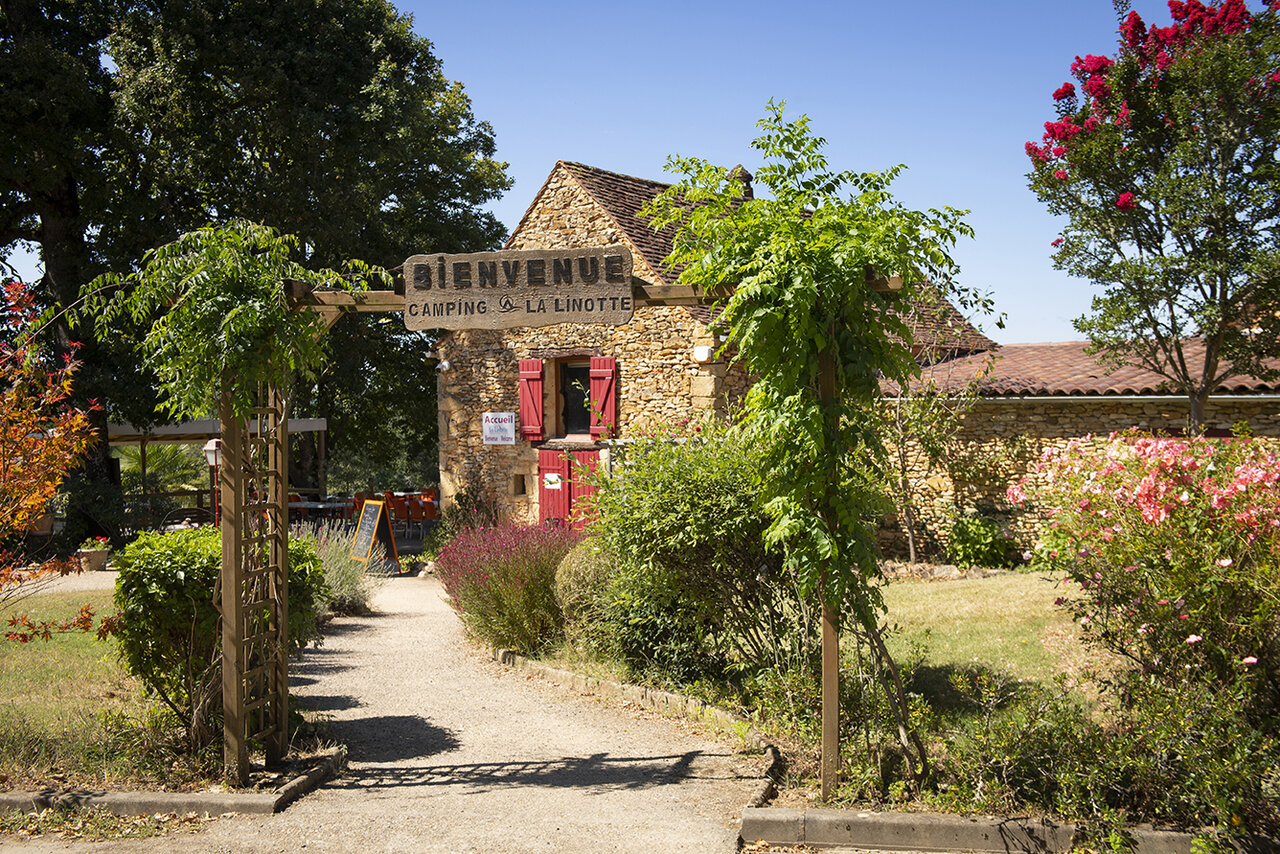 Main entrance and stone reception building at Camping La Linotte in Le Bugue (24).