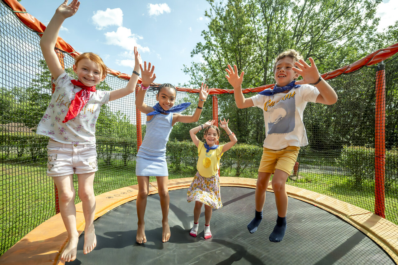 Children jumping on outdoor trampoline at CLICOCHIC Linotte campsite in Le Bugue (24).