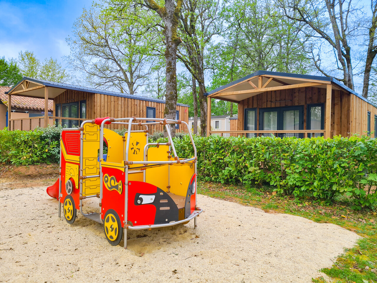 Children's playground and modern mobile homes at CLICOCHIC Linotte campsite in Le Bugue (24).