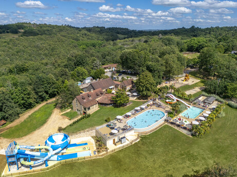 Aerial view of water park with pools, slides and playground at CLICOCHIC Linotte campsite in Le Bugue (24).