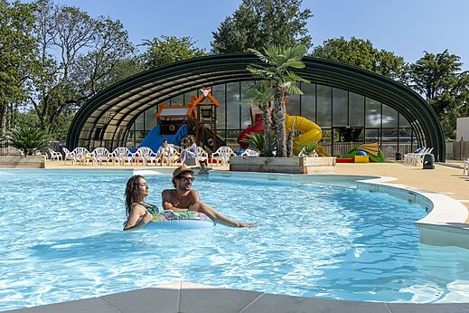Outdoor pool with slides and water games at CAPFUN Lodge campsite SARZEAU (56).