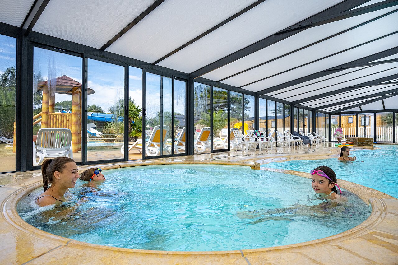 Jacuzzi and indoor pool with outdoor slide at CLICOCHIC Longchamp campsite in Saint Lunaire (35).
