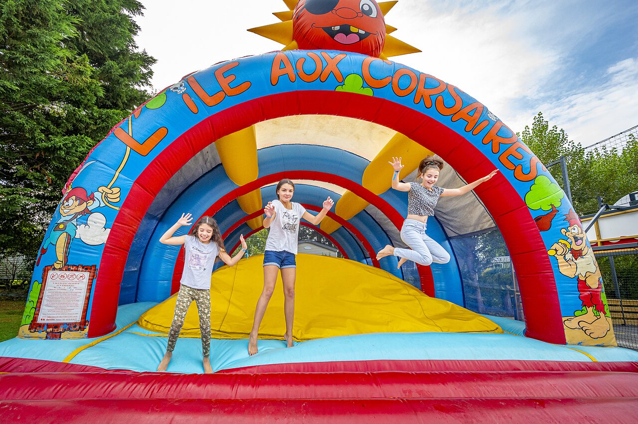 Inflatable game Pirates' Island, children having fun at CLICOCHIC Longchamp campsite.