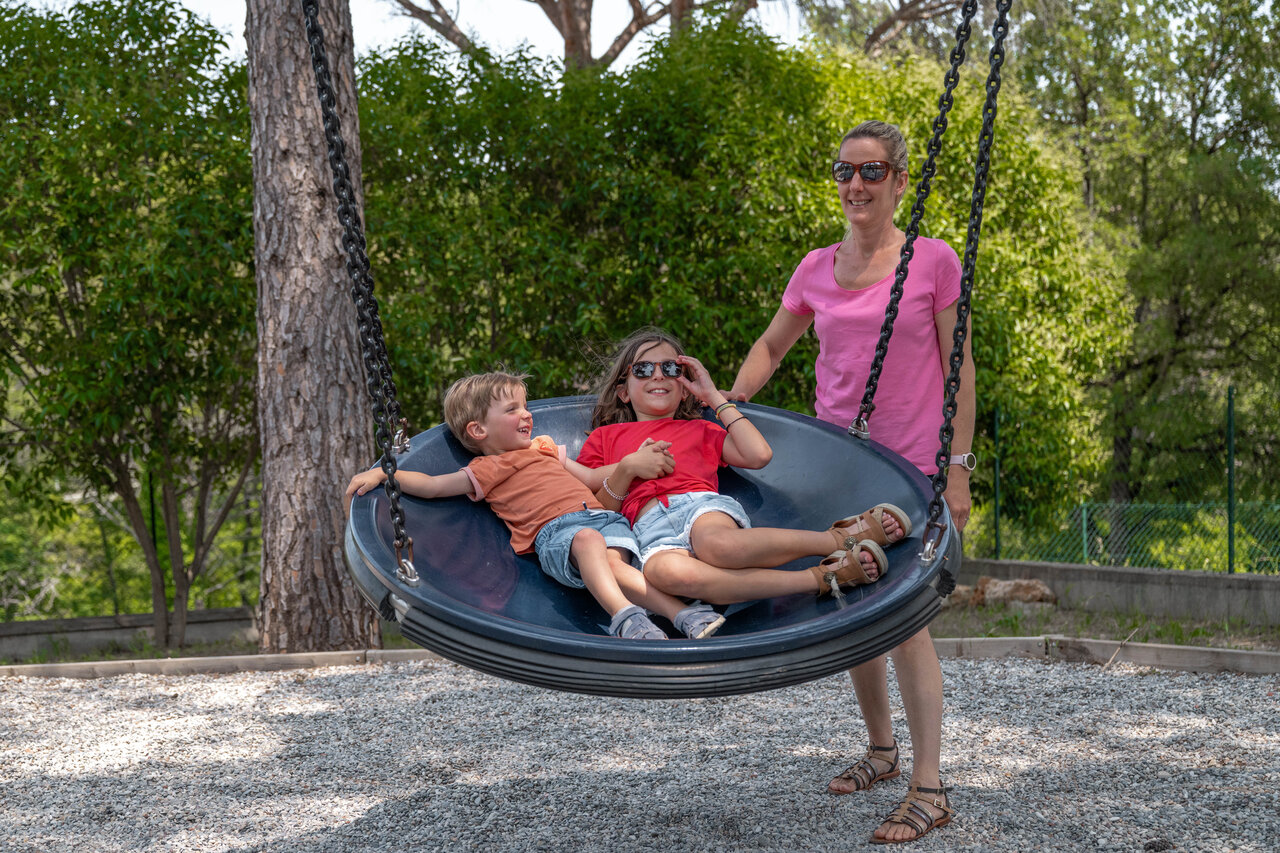 Saucer swing, children and woman at CLICOCHIC Lou Cantaire campsite in FAYENCE (83).
