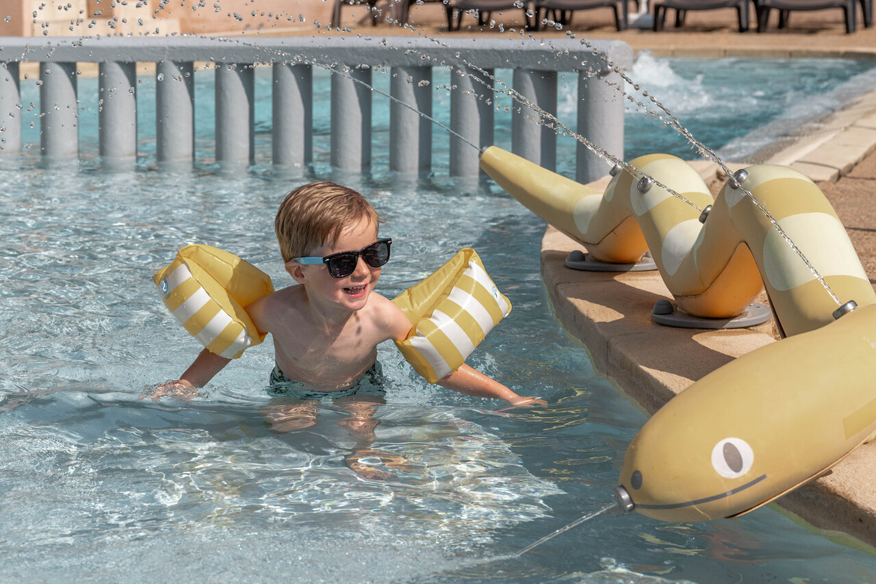 Smiling child with armbands, water games pool camping CLICOCHIC Lou Cantaire Fayence.