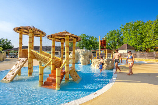 Aquatic play area with slides and tipping bucket at CLICOCHIC Lou Castel campsite in Castelnaud-la-Chapelle (24).