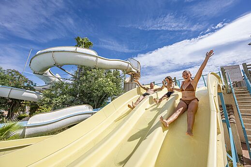 Happy family on giant water slide at CAPFUN Lou Village campsite in Vendres (34).