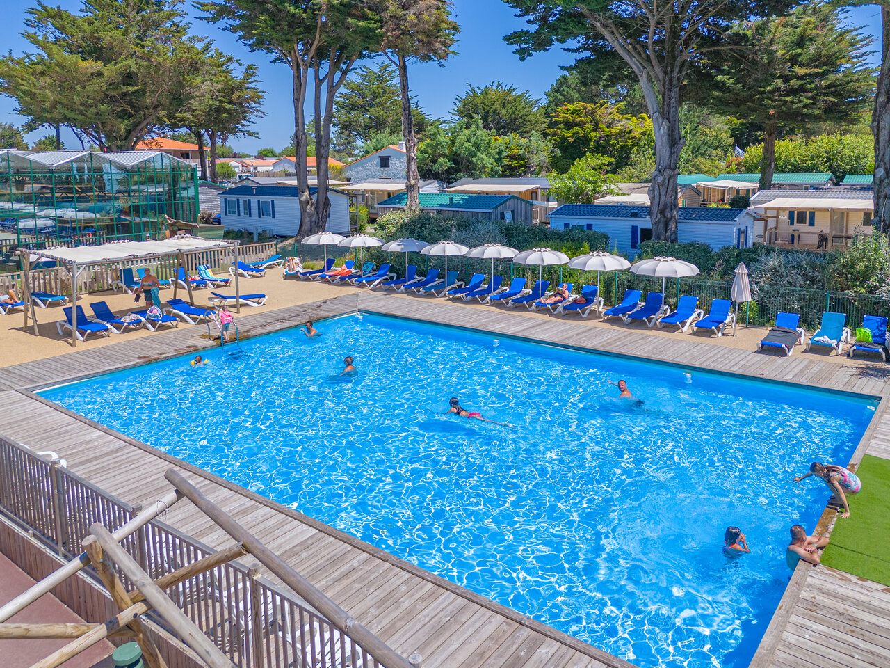 Sunny outdoor pool, swimmers, sun loungers, mobile homes CAPFUN Madrague in PORNIC (44).