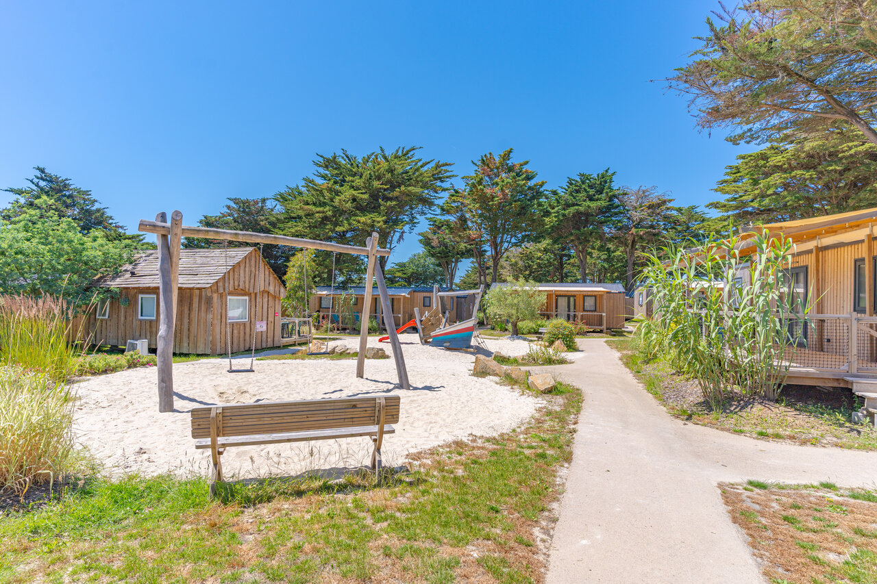 Sandy playground with swings and Mobil-homes at CAPFUN Madrague campsite in PORNIC (44).