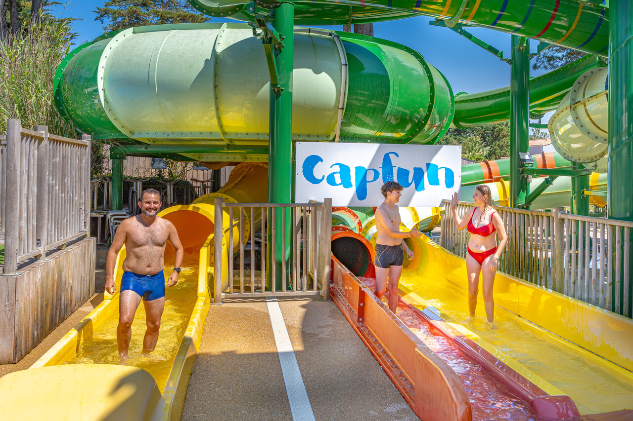 Colorful water slides and family having fun at CAPFUN Madrague campsite in PORNIC (44).