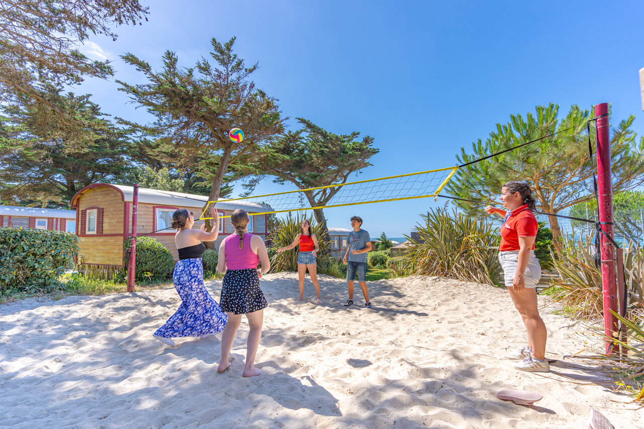 Beach volleyball court with young people and animator at CAPFUN Madrague campsite in PORNIC (44).