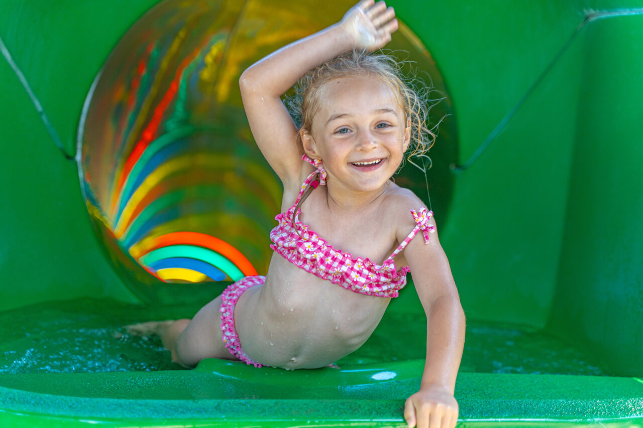 Smiling child on colorful water slide at CAPFUN Madrague campsite in PORNIC (44).