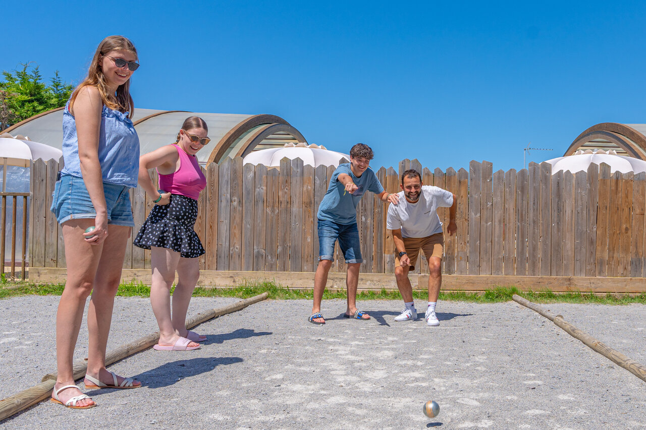 Family playing p�tanque on a sunny court at CAPFUN Madrague campsite in PORNIC (44).