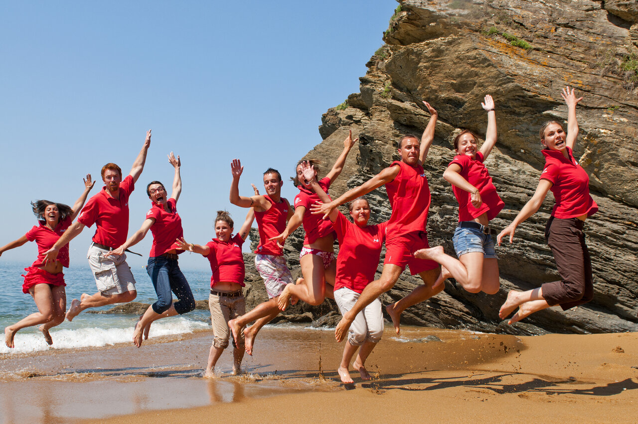 Smiling animators jumping on the beach, CAPFUN Madrague campsite PORNIC (44).