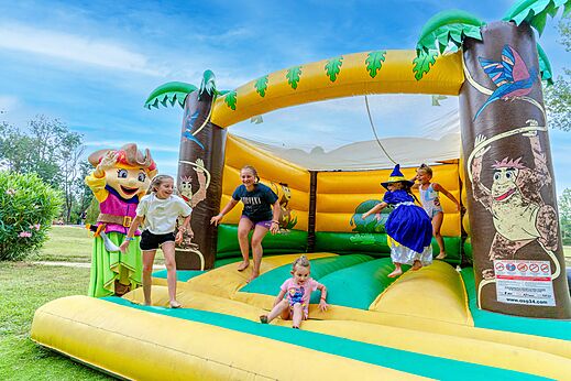 Giant inflatable bouncy castle with children and mascot at CAPFUN Mael campsite in ARGELES SUR MER (66).