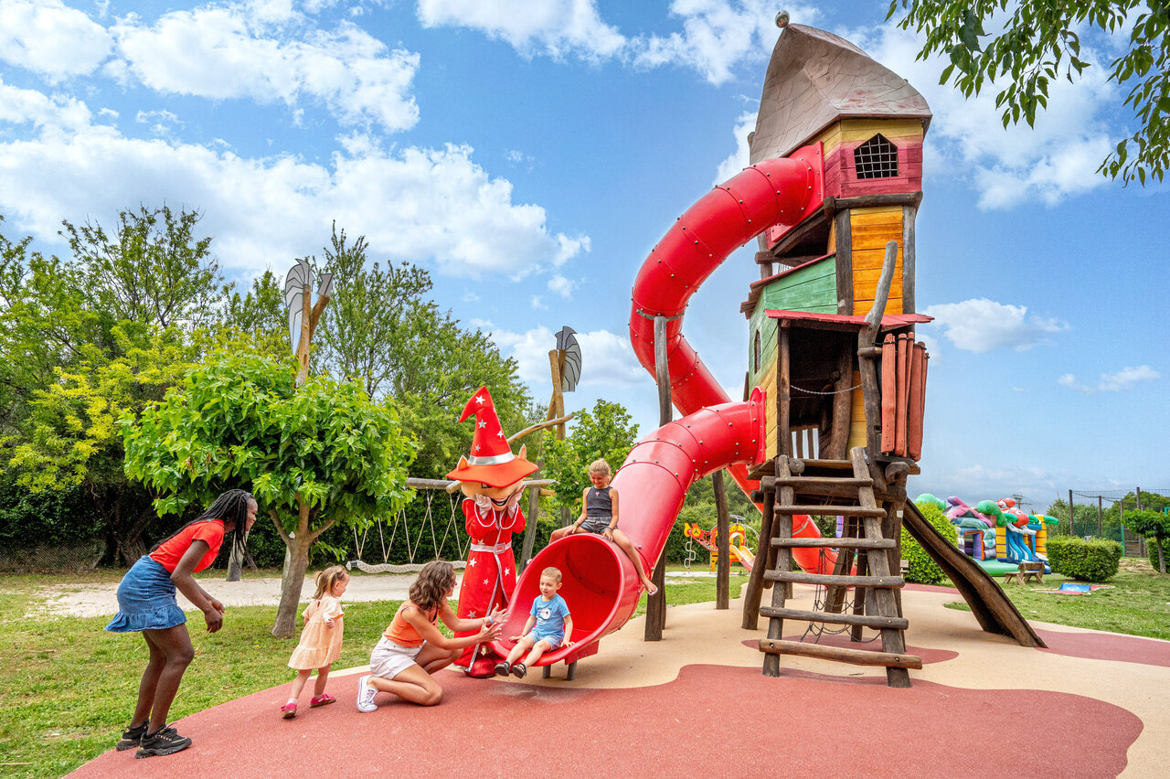 Giant slide and playground with children and mascot at CAPFUN Malissonne campsite in LA CADIERE D'AZUR (83).