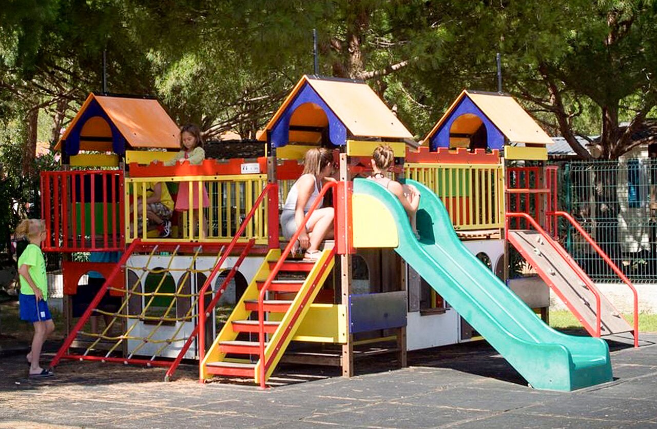 Colorful children's playground with slides and kids at VAGUES OCEANES Manoir de Balkos campsite in Valras-Plage (34).