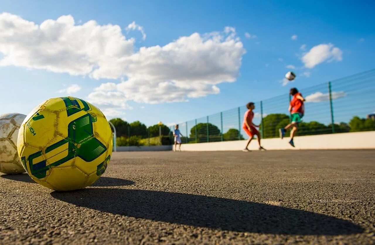 Football and children playing at VAGUES OCEANES Manoir de Balkos campsite in Valras-Plage (34).