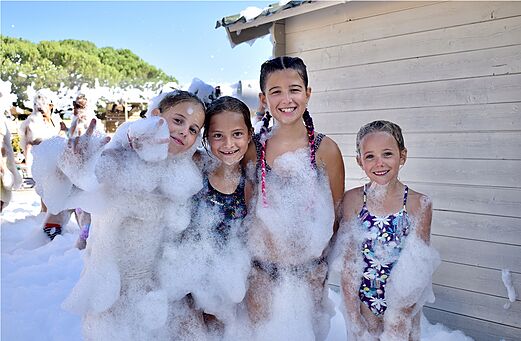 Joyful foam party, smiling children, VAGUES OCEANES Manoir de Balkos campsite.