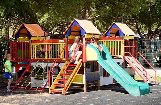 Colorful children's playground with slides and kids at VAGUES OCEANES Manoir de Balkos campsite in Valras-Plage (34).