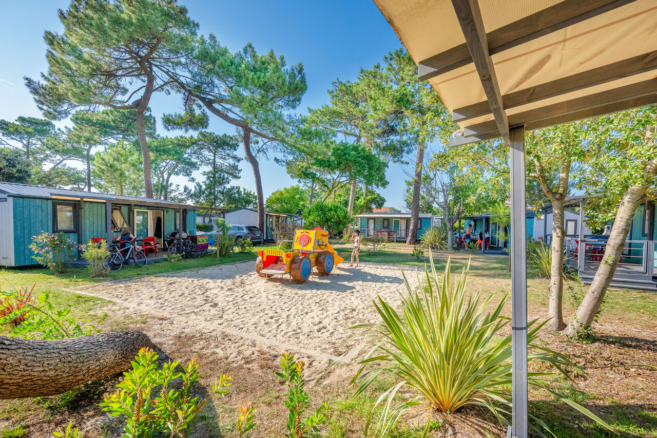 Mobile homes, playground and pine trees at VAGUES OCEANES Marina Landes campsite in Mimizan (40).