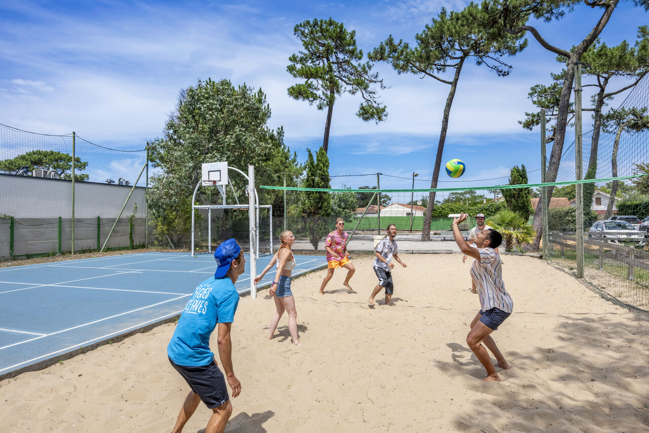 Beach volleyball court with players at VAGUES OCEANES Marina Landes campsite, Mimizan.