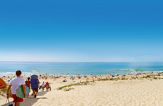 Sandy beach access, swimmers and ocean at VAGUES OCEANES Marina Landes campsite.