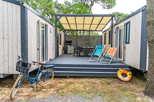 Modern mobile home, terrace and bicycle at VAGUES OCEANES Marina Landes campsite in Mimizan (40).