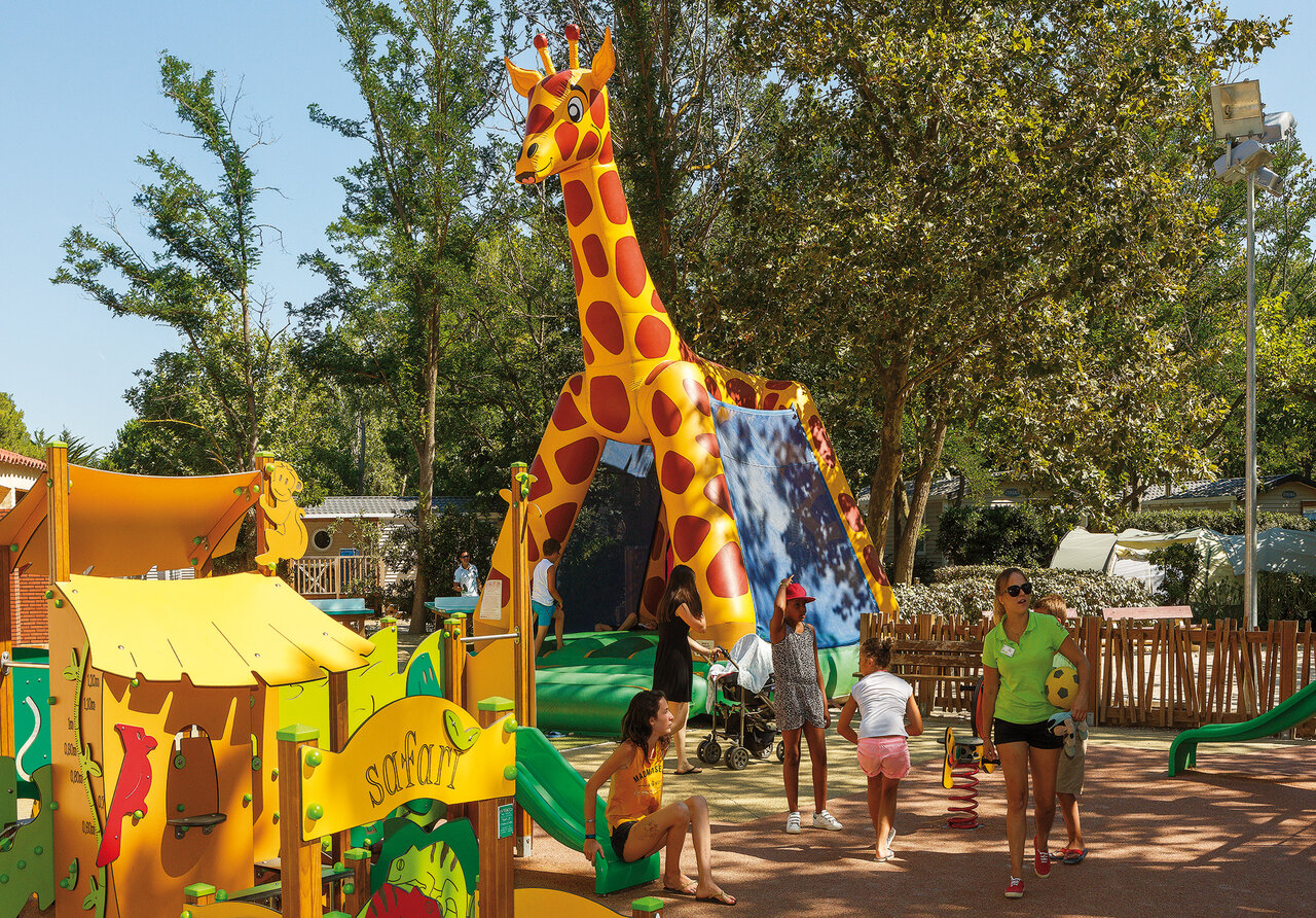 Inflatable giraffe slide and playground at VAGUES OCEANES Marinette campsite in Ste Marie La Mer (66).