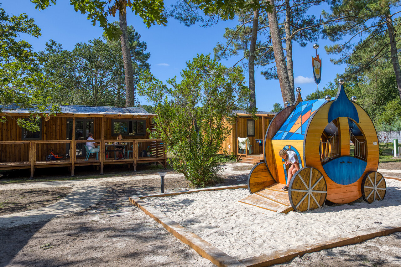 Carriage-shaped play structure and Mobil-homes at CLICOCHIC M�doc Bleu campsite in Carcans (33).