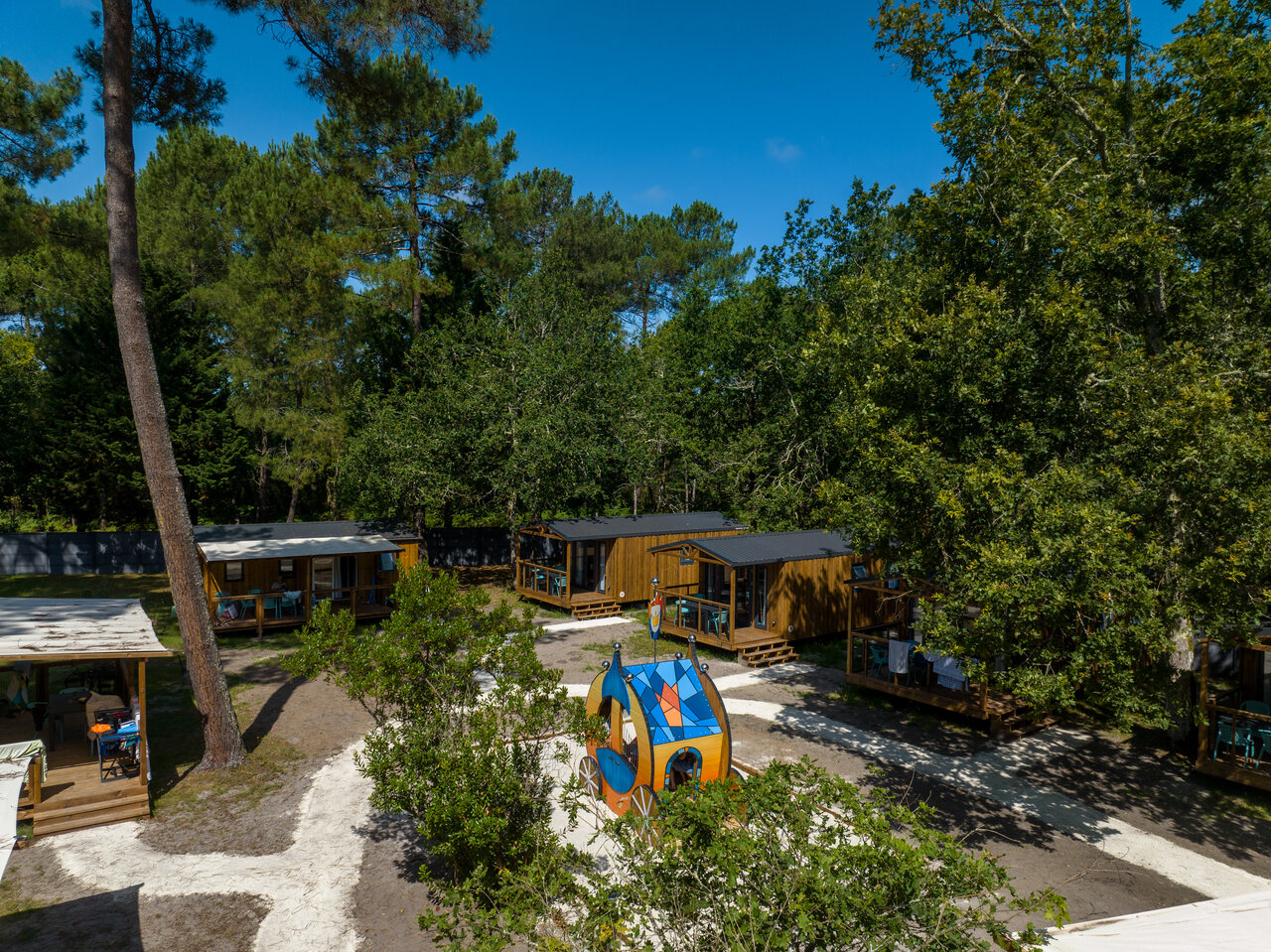 Wooden mobile homes, playground at CLICOCHIC M�doc Bleu campsite Carcans (33).
