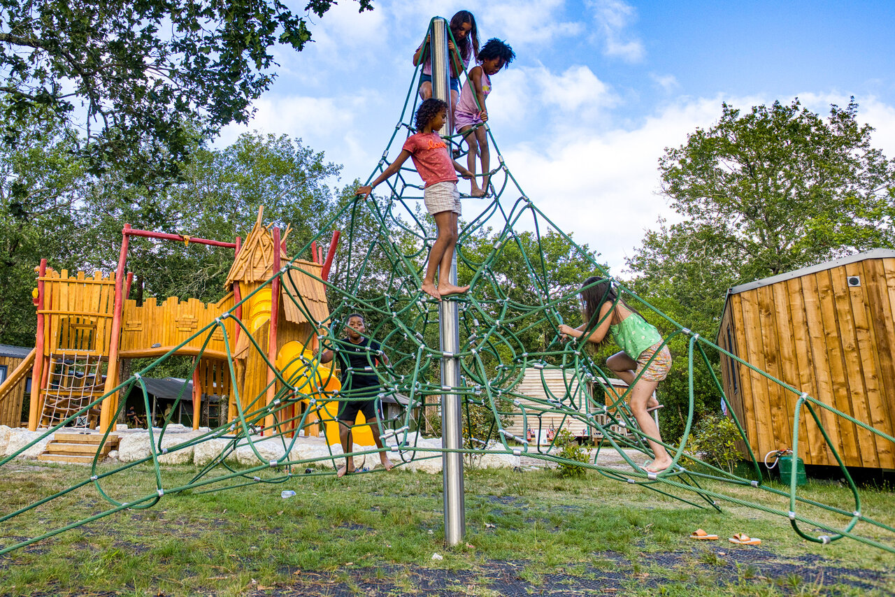 Children on rope climbing structure, playground, CLICOCHIC M�doc Bleu campsite.