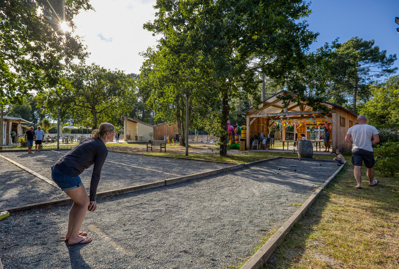 Petanque court with players and animation area at CLICOCHIC M�doc Bleu campsite in Carcans (33).