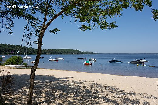 Sandy beach and boats on Lake Hourtin, Gironde.