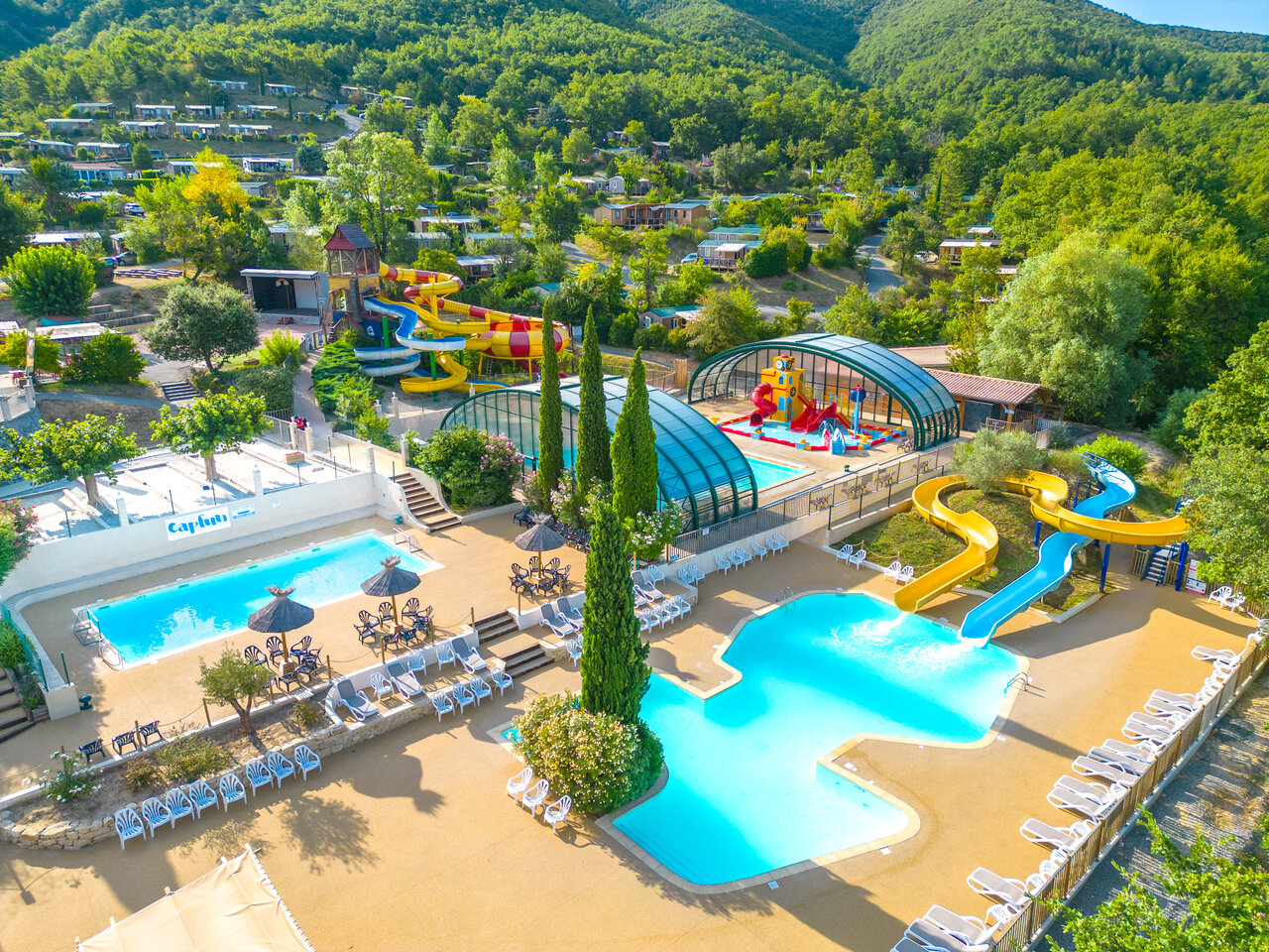 Aquatic complex with pools, slides, and water games at CAPFUN Merle Roux campsite in Baix (07).