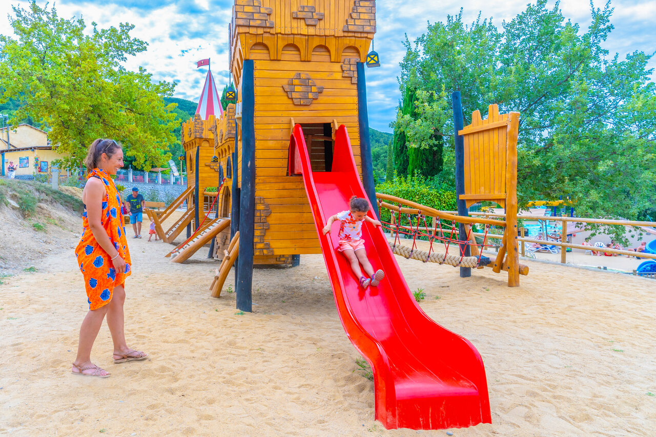 Child on red slide of play castle, CAPFUN Merle Roux, Baix (07).