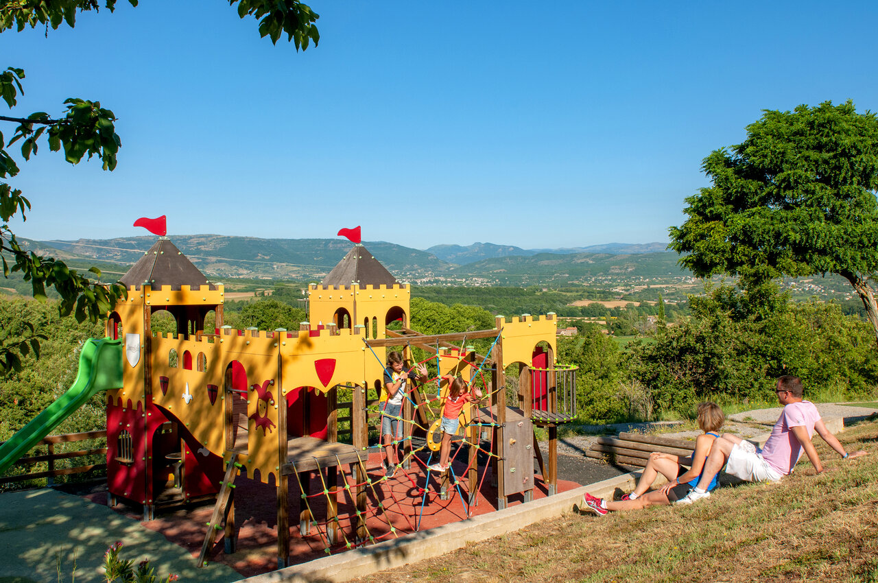 Castle playground with slide and panoramic view at CAPFUN Merle Roux campsite in Baix (07).