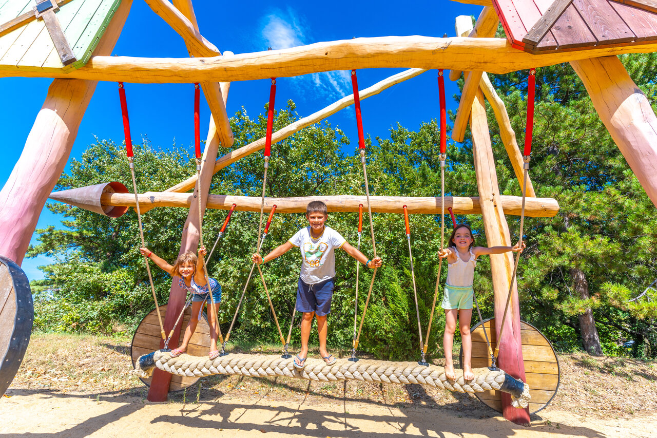 Wooden playground, smiling children at CAPFUN Merle Roux campsite (07).