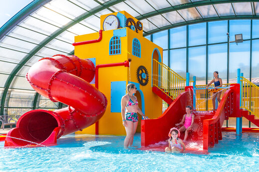 Covered water park with slide and water games at CAPFUN Merle Roux in Baix (07).