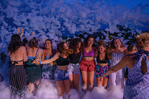 Smiling group of young people enjoying a lively foam party at CAPFUN Merle Roux campsite in Baix (07).