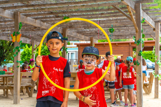 Smiling children enjoying Mini Club animation at CAPFUN Merle Roux campsite in Baix (07).