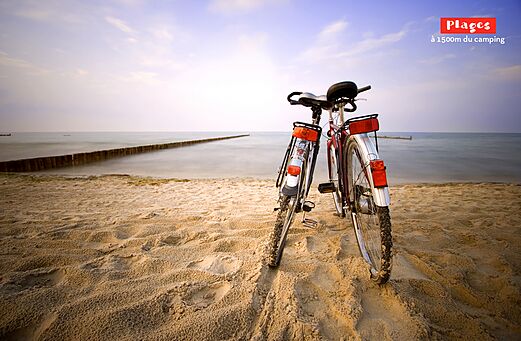Two bicycles on a fine sandy beach near the sea at CAPFUN Mer et Soleil campsite in Cap d'Agde (34).