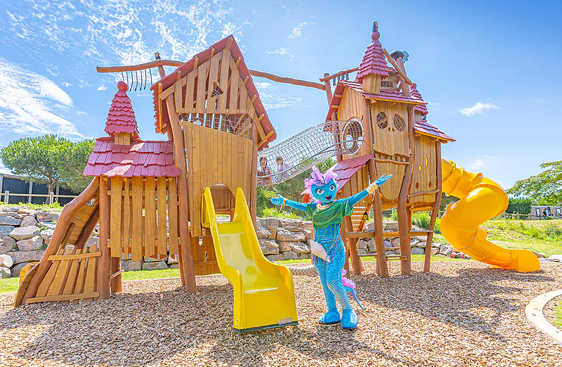 Wooden playground, slides, mascot at VAGUES OCEANES Micheli�re campsite.