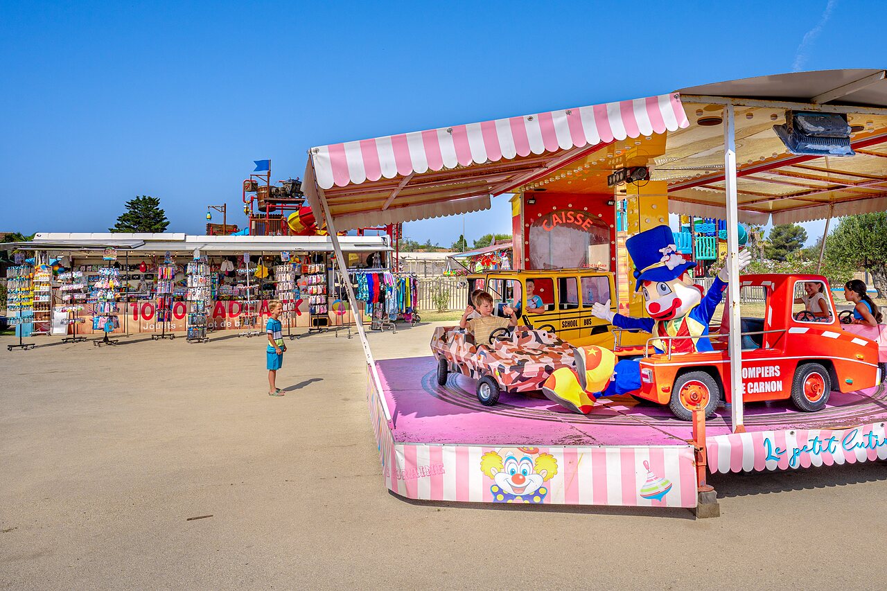 Children's carousel, clown and fun vehicles at CAPFUN Mille P�pites campsite in Carnon (34).