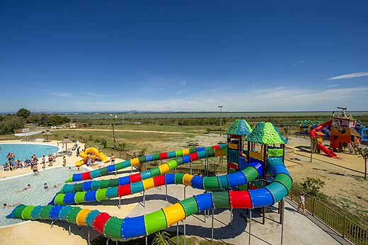 Colorful water slides and outdoor swimming pool at CAPFUN Mille Pépites campsite in Carnon (34).